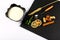 Yoghurt plate, mint leaves, slices of lemon, wheat, nuts, a sticks of cinnamon and a spoon on a black shale board, on a white back