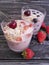 Yoghurt, strawberry, cherry, morning cereal muesli blueberry glass on a black wooden background