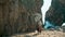 Yogi girl standing upside down on sand rocky Ursa beach. Woman making yoga asana