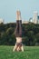 Yogi woman doing stretching workout in park outdoors at sunset.