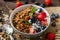 Yogurt with baked granola and berries in small bowl