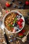 Yogurt with baked granola and berries in small bowl