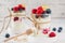 Yogurt with berries, cereals and honey in a glass on white background