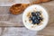 Yogurt with blueberries, granola, above view on rustic wood