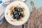 Yogurt with blueberries, granola, close up over a wooden background