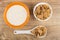 Yogurt in bowl, flakes in bowl, in spoon on table