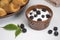 Yogurt in bowls with berries and a plate with croissants.