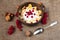 Yogurt,corn flakes,red currant and nuts on rustic background