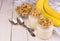 Yogurt with granola and banana on a white wooden background. The concept of dessert desserts. Top view.