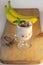 Yogurt Jelly Dessert with banana, strawberry, cocoa, fresh mint in a glass on wooden cut board.Healthy vegan sweet jello