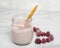 A yogurt with a raspberry
