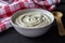 Yogurt in a white bowl on rustic black wooden table