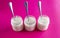 Yogurts in glass jars with spoons on a pink background