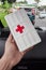 Yogyakarta, Indonesia - December 31, 2021:Close-up of hands holding first aid kit with red cross symbol in car