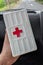 Yogyakarta, Indonesia - December 31, 2021:Close-up of hands holding first aid kit with red cross symbol in car