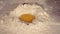 Yolk falling into flour closeup, slow motion. Egg Falls into Flour.