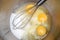 Yolks in a stainless steel bowl with a whisk