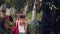 Yong female traveller walking in jungle with parrot and waterfall.