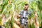 Yong handsome agronomist in the corn field and examining crops before harvesting. Agribusiness concept. agricultural