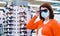 Yong woman in medical mask trying on sunglasses in shopping center