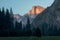 Yosemite National Park view of Half Dome from the Valley during colorful sunset with trees and rocks. California, USA
