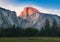 Yosemite National Park view of Half Dome from the Valley during colorful sunset with trees and rocks. California, USA