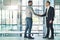 You deserve this promotion. Shot of two businessmen shaking hands together in an office.