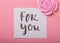 For You handwritten inscription. Hand drawn lettering,  calligraphy. card with Pink  Rose candy in pastel colors on a wooden stick