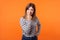 You are liar. Portrait of angry woman with brown hair in casual shirt showing lie gesture. indoor studio shot  on orange