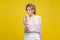 You are liar. Portrait of dishonest young woman with fair hair in casual beige blouse,  on yellow background