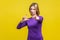 You are loser! Portrait of bossy serious businesswoman showing loser gesture and pointing at camera.  on yellow background