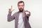 You are loser! Portrait of serious bossy bearded man pointing at camera and showing loser gesture. white background