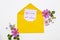 You are not alone message card handwriting in yellow envelope with pink  flowers cosmos arrangement flat lay postcard