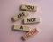 You are not your a victim. Wooden blocks with words You are not a victim. Beautiful pink background. Business and You are not a