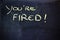 You\'re fired message on chalkboard