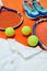 Are you ready for a game. High angle shot of tennis essentials placed on top of an orange background inside of a studio.