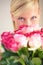 You shouldnt have - but Im glad you did. Portrait of a young woman peering over a bouquet of pink roses.