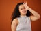 You stink. Cropped portrait of an attractive young woman gesturing that something stinks in studio against a red