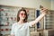 You think I should buy glasses or not. Portrait of glamourous attractive woman on shopping standing in optician store