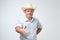 You are welcome concept. Cheerful mature man in blue shirt and cowboy hat gesturing welcome sign