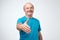 You are welcome concept. Cheerful mature man in blue t-shirt gesturing welcome sign and smiling