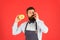 You will lick your fingers. Bearded man enjoying sweet taste of doughnut on red background. Baker eating donut with