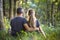 Youg couple, man and a woman sitting together outdoors enjoying nature