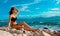 Youg girl in bikini sitting on beach