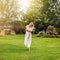 Youmg beautiful blond woman in beautiful summer garden is barefoot on lawn