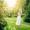 Youmg beautiful blond woman in beautiful summer garden is barefoot on lawn