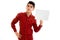 Youn attractive brunette male model in red shirt posing with empty placard in his hands and looking at the camera