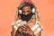 Yound african woman with blond dreadlocks using mobile phone while listening playlist music - Trendy person having fun with