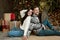 Yound couple husband sitting with his back to his beloved beautiful wife in room decorated for celebrating new year looking happy