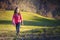 Young active girl walking over the green meadows